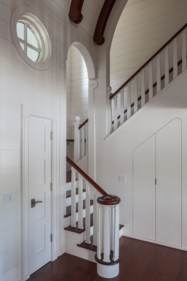 На фото: п-образная лестница среднего размера в морском стиле с деревянными ступенями, крашенными деревянными подступенками и деревянными перилами