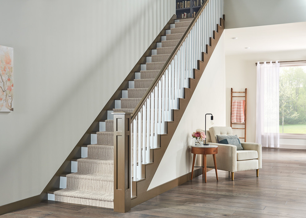 Example of a beach style carpeted straight wood railing staircase design in Boston with carpeted risers