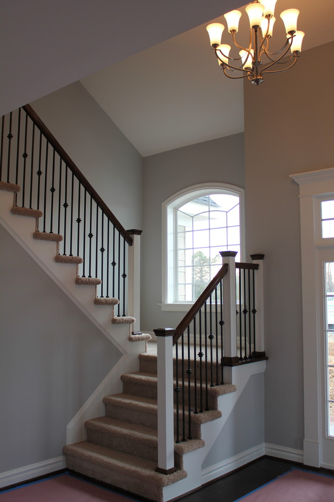 Идея дизайна: п-образная лестница среднего размера в стиле неоклассика (современная классика) с ступенями с ковровым покрытием, ковровыми подступенками и деревянными перилами