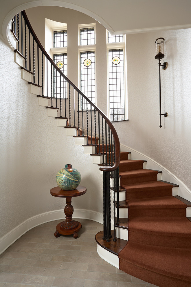 Ejemplo de escalera curva clásica con escalones de madera y contrahuellas de madera pintada