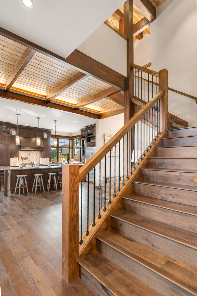 Foto de escalera en L rústica con escalones de madera, contrahuellas de madera y barandilla de madera