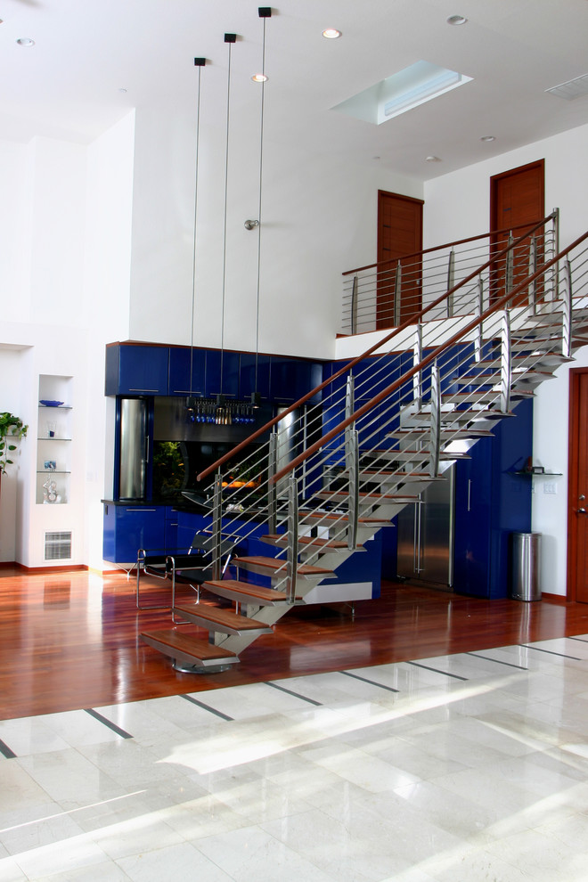 Diseño de escalera recta contemporánea grande sin contrahuella con escalones de madera y barandilla de metal
