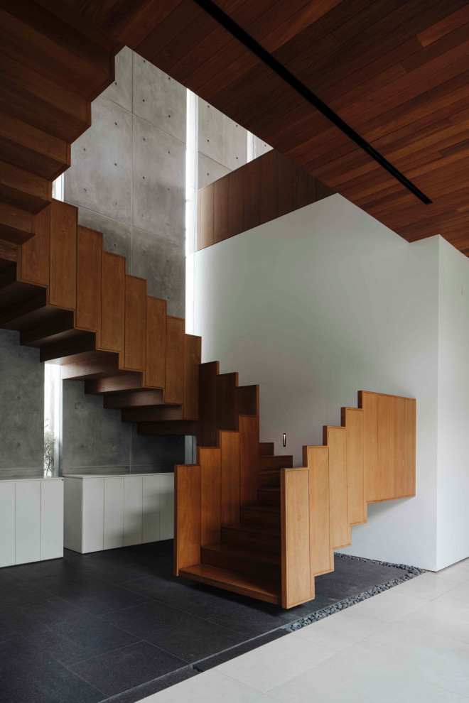 This is an example of a large contemporary wood u-shaped staircase in Singapore with wood risers.