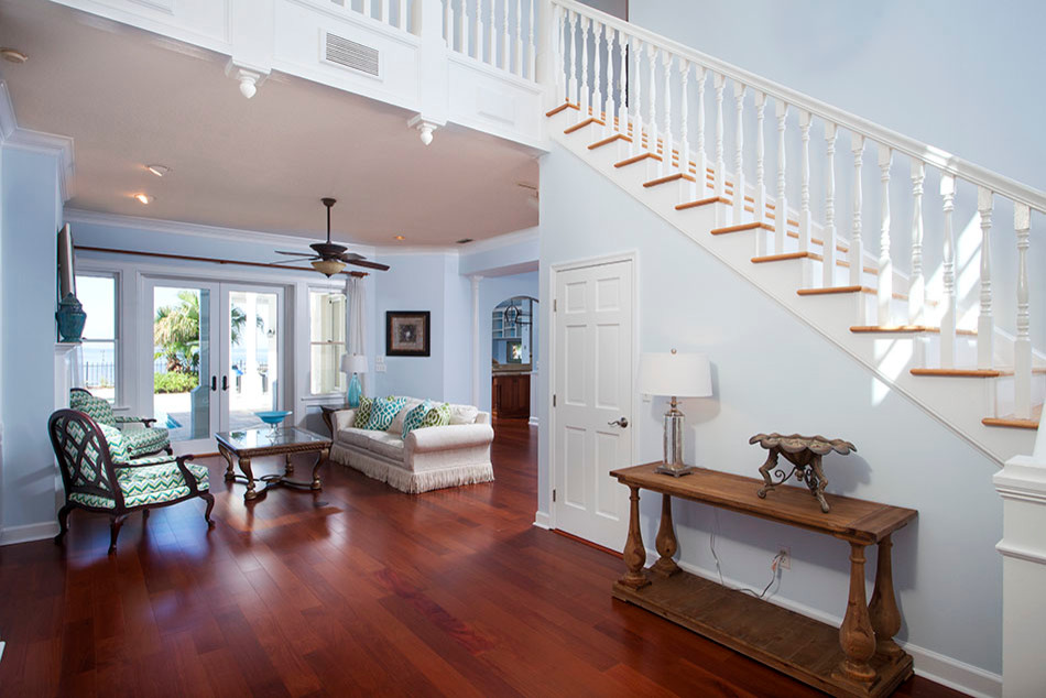 Large island style wooden l-shaped staircase photo in Tampa with painted risers