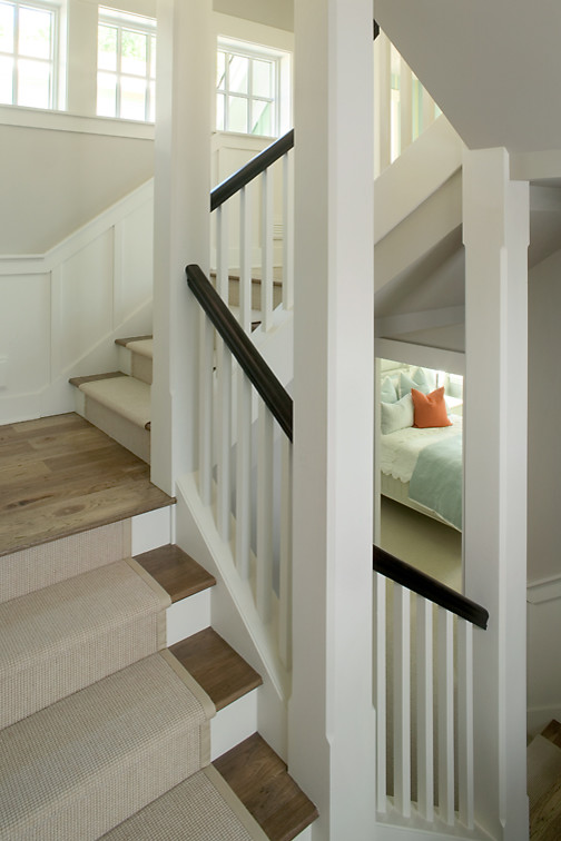 Imagen de escalera en U clásica de tamaño medio con escalones de madera, contrahuellas de madera pintada y barandilla de varios materiales