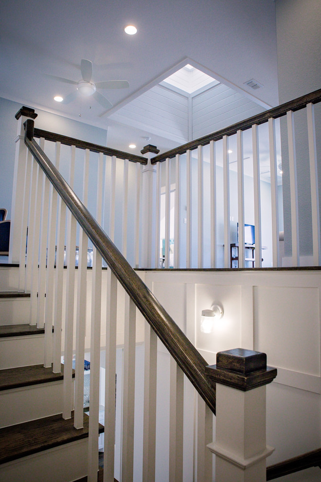 На фото: п-образная лестница среднего размера в стиле кантри с деревянными ступенями, крашенными деревянными подступенками и деревянными перилами с