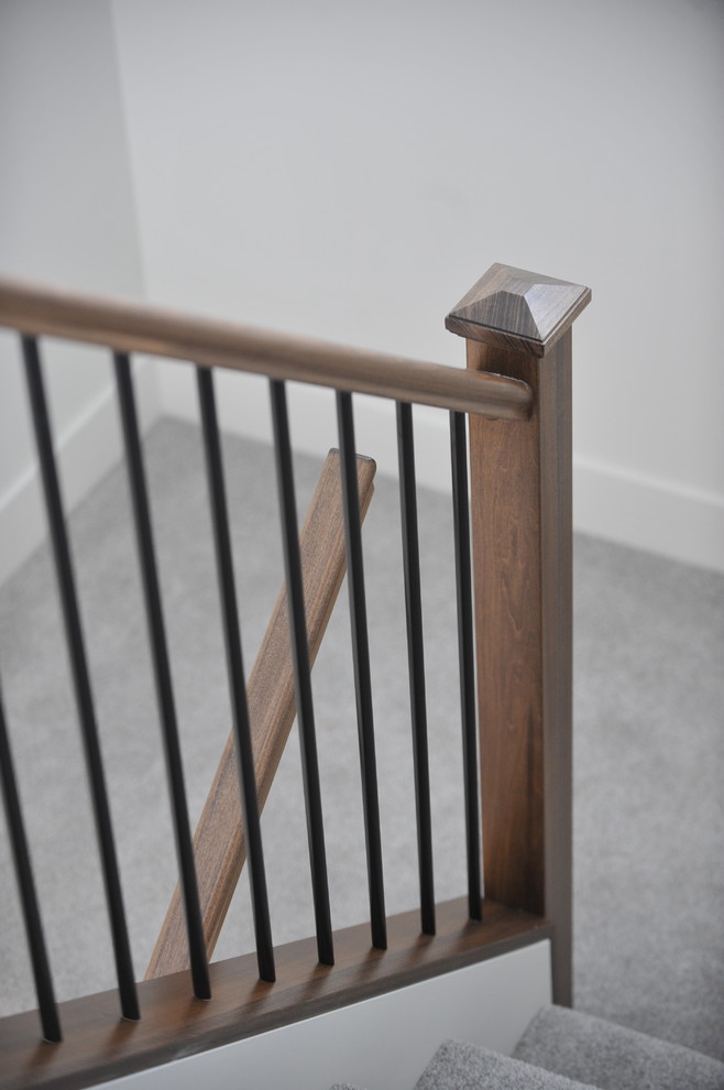 Стильный дизайн: п-образная лестница среднего размера в современном стиле с ступенями с ковровым покрытием, ковровыми подступенками и деревянными перилами - последний тренд