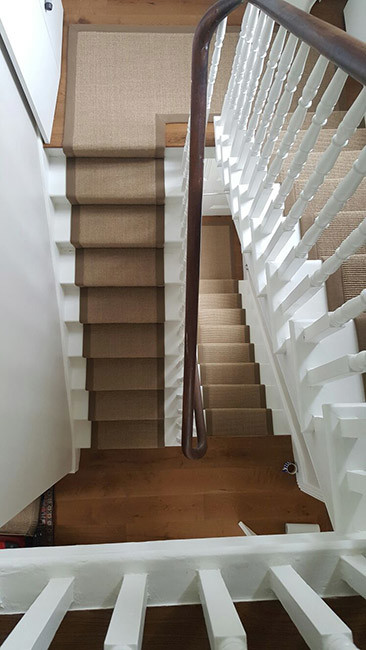 Medium sized contemporary carpeted u-shaped wood railing staircase in London with carpeted risers.