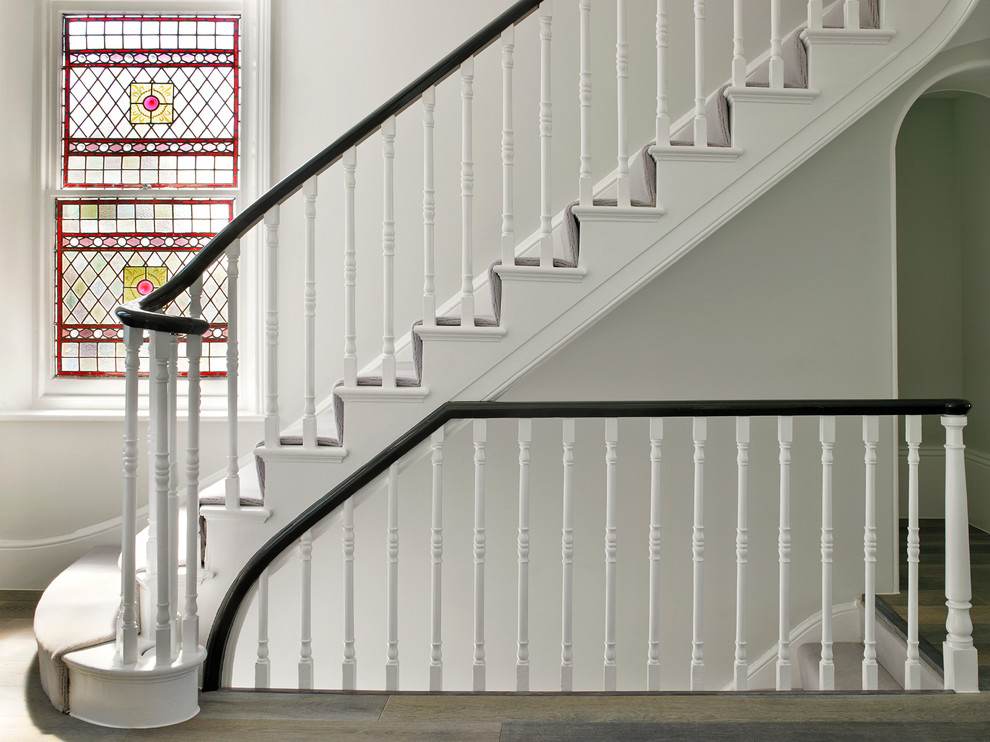 ロンドンにあるトラディショナルスタイルのおしゃれな階段 (カーペット張りの蹴込み板) の写真