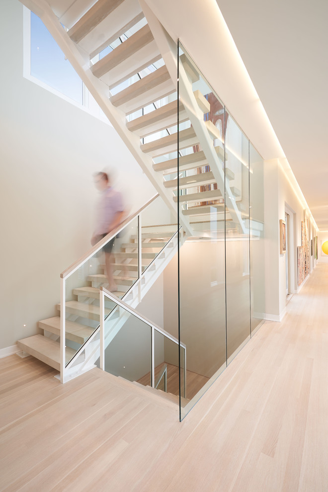 Nautical wood floating glass railing staircase in Wilmington with open risers.