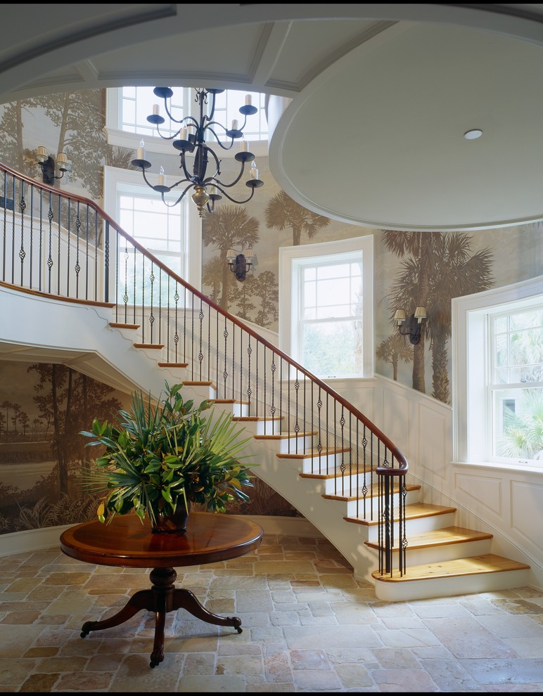 Staircase - huge traditional wooden curved staircase idea in Charleston with painted risers