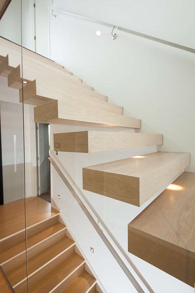 Foto de escalera suspendida minimalista de tamaño medio sin contrahuella con escalones de madera