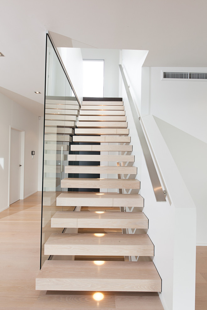 Ejemplo de escalera suspendida moderna de tamaño medio sin contrahuella con escalones de madera