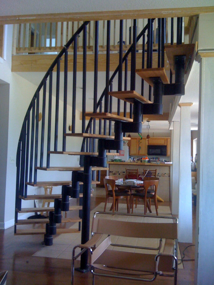 Mid-sized elegant wooden curved open and metal railing staircase photo in Other