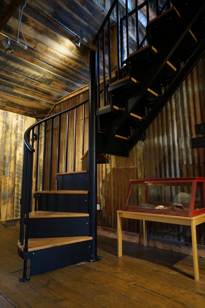 Cette image montre un escalier hélicoïdal rustique de taille moyenne avec des marches en bois et des contremarches en métal.