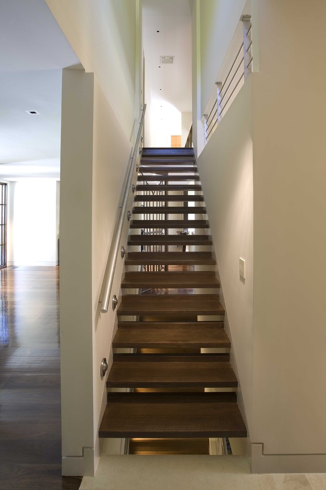 Foto de escalera recta minimalista de tamaño medio sin contrahuella con barandilla de metal y escalones de madera