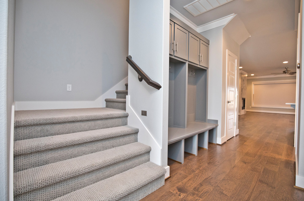 Идея дизайна: угловая лестница среднего размера в современном стиле с ступенями с ковровым покрытием, ковровыми подступенками и деревянными перилами