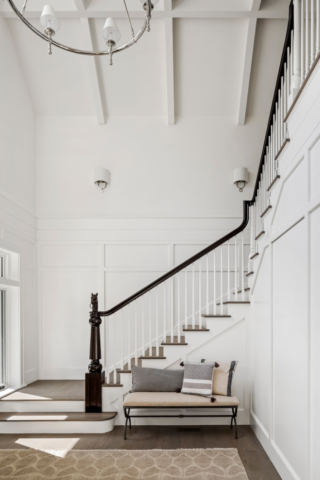 Стильный дизайн: большая угловая лестница в стиле кантри с деревянными ступенями, крашенными деревянными подступенками и деревянными перилами - последний тренд