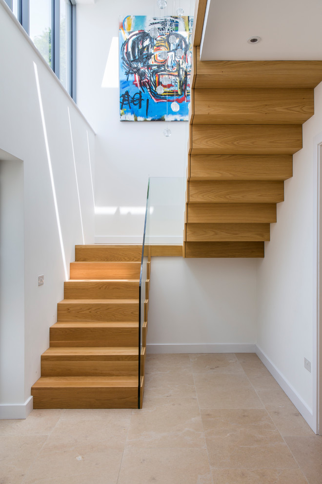 На фото: п-образная деревянная лестница в современном стиле с деревянными ступенями и стеклянными перилами