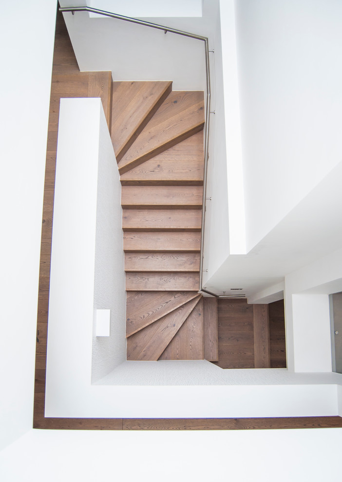 Aménagement d'un grand escalier contemporain avec des marches en bois et des contremarches en bois.