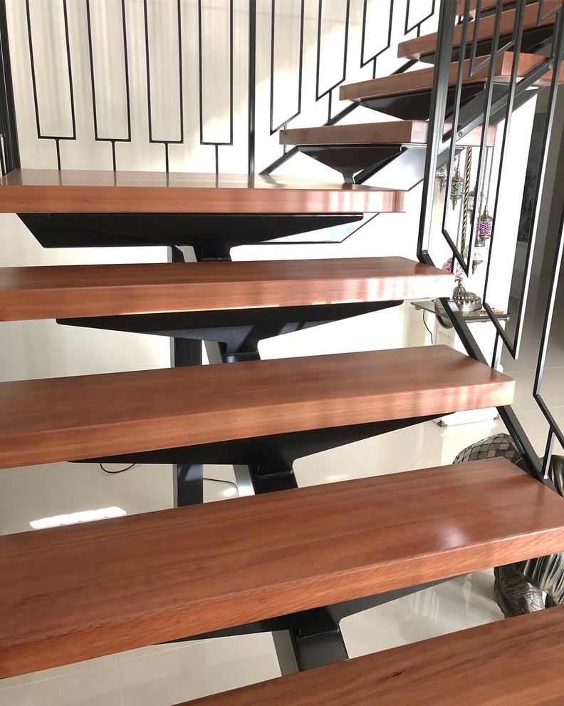 На фото: угловая лестница в современном стиле с деревянными ступенями и металлическими перилами