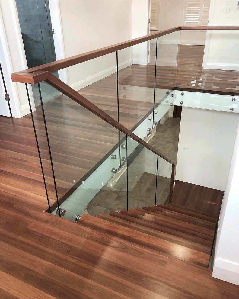 This is an example of a contemporary wood l-shaped wood railing staircase in Sydney with wood risers.