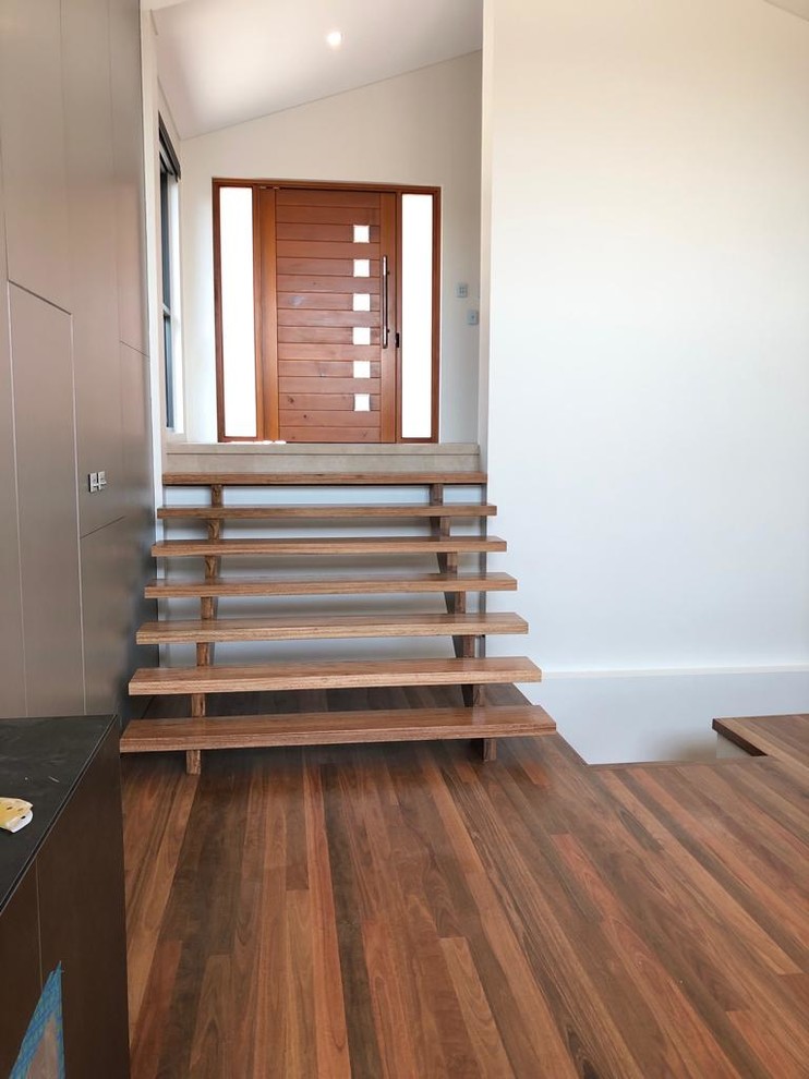 Inspiration pour un escalier droit design avec des marches en bois et un garde-corps en bois.