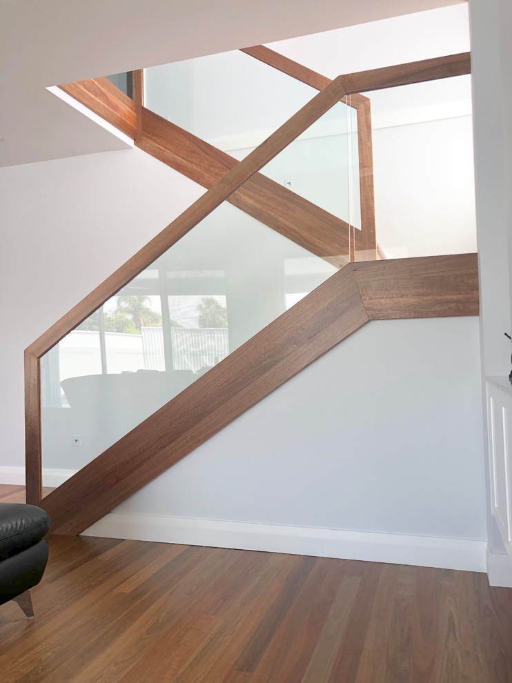 На фото: п-образная деревянная лестница в современном стиле с деревянными ступенями и деревянными перилами