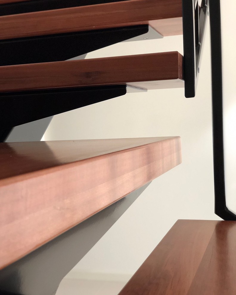 На фото: угловая лестница в современном стиле с деревянными ступенями и металлическими перилами с