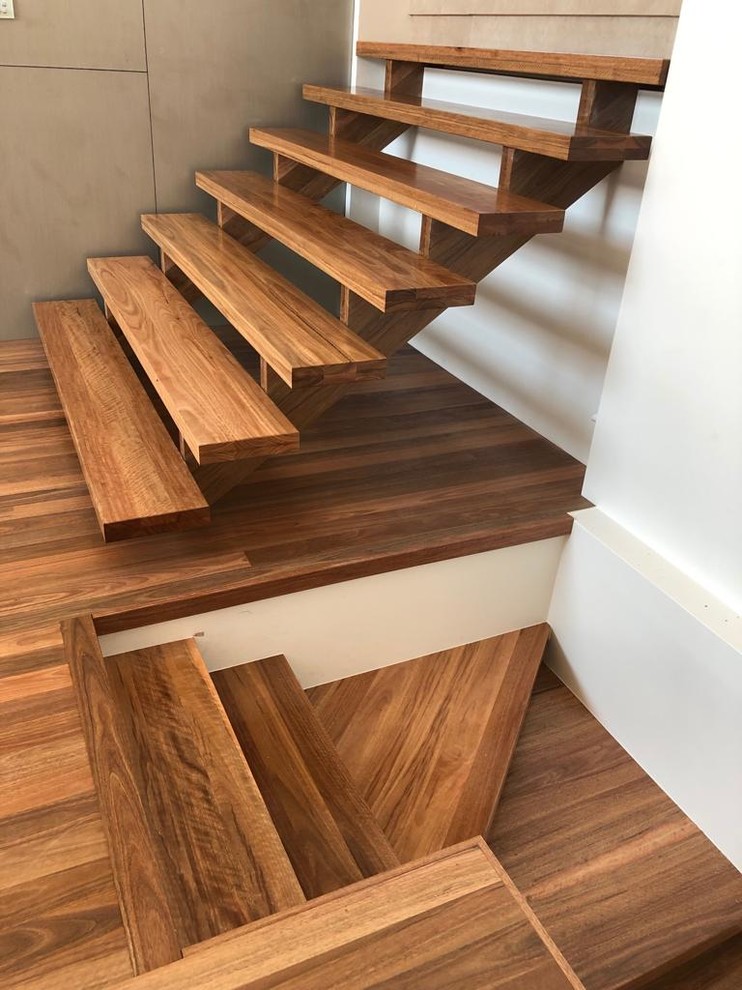 Ejemplo de escalera en L actual con escalones de madera y barandilla de madera
