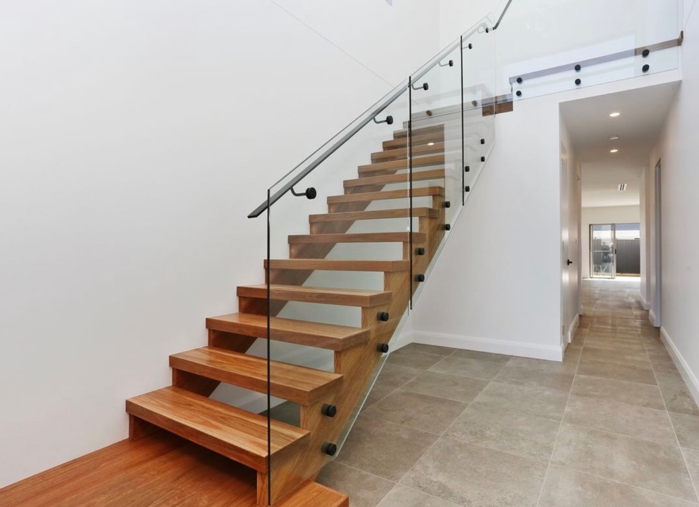 Modelo de escalera en L actual con escalones de madera y barandilla de metal
