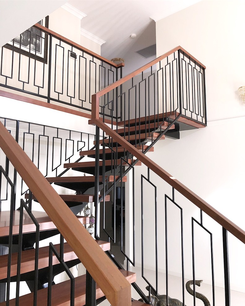 Стильный дизайн: угловая лестница в современном стиле с деревянными ступенями и металлическими перилами - последний тренд