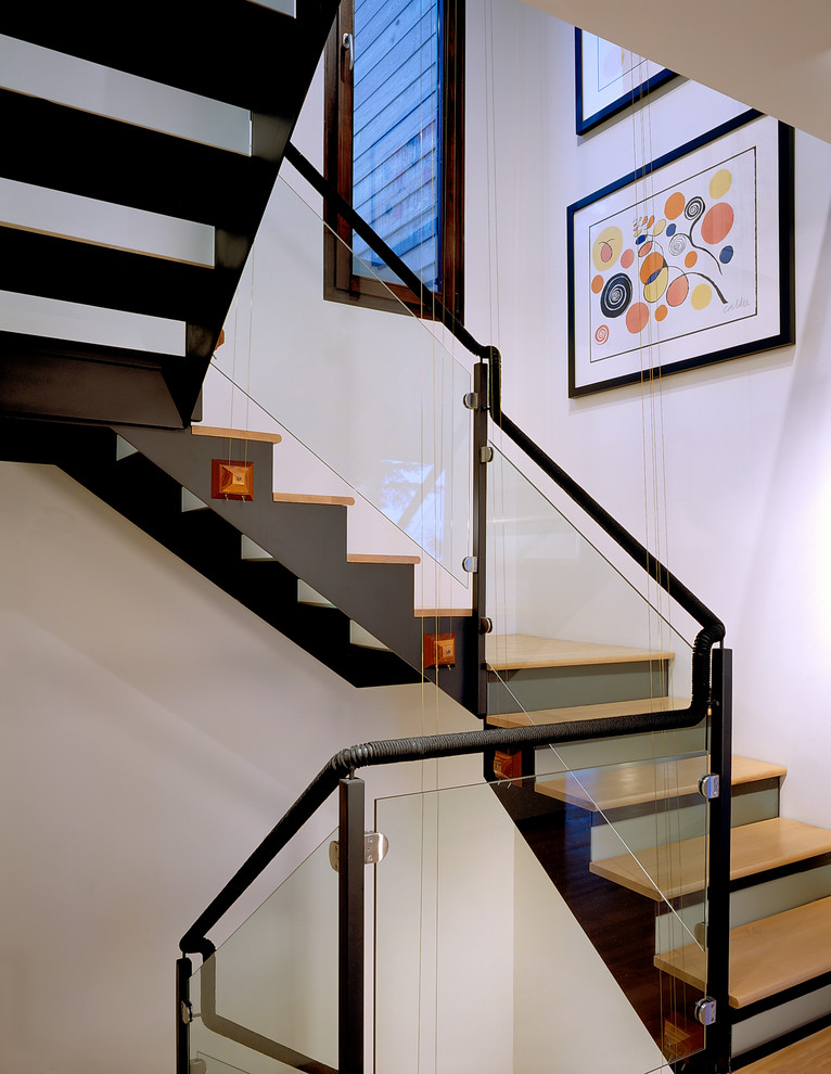 На фото: лестница в современном стиле с деревянными ступенями и стеклянными подступенками