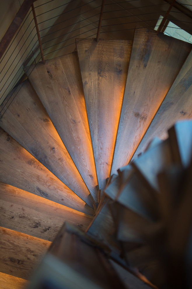 Idées déco pour un grand escalier sans contremarche courbe industriel avec des marches en bois.