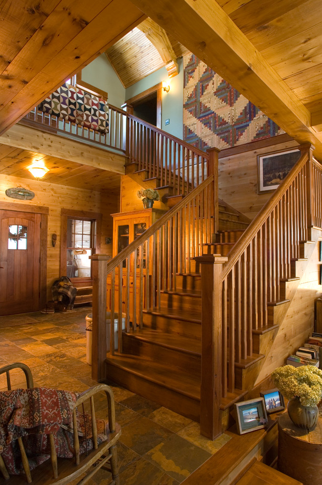 На фото: угловая деревянная лестница в стиле рустика с деревянными ступенями с