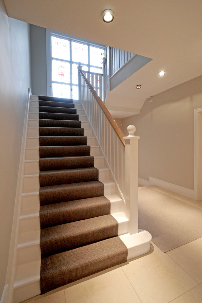 Example of a trendy carpeted staircase design in Oxfordshire with wooden risers
