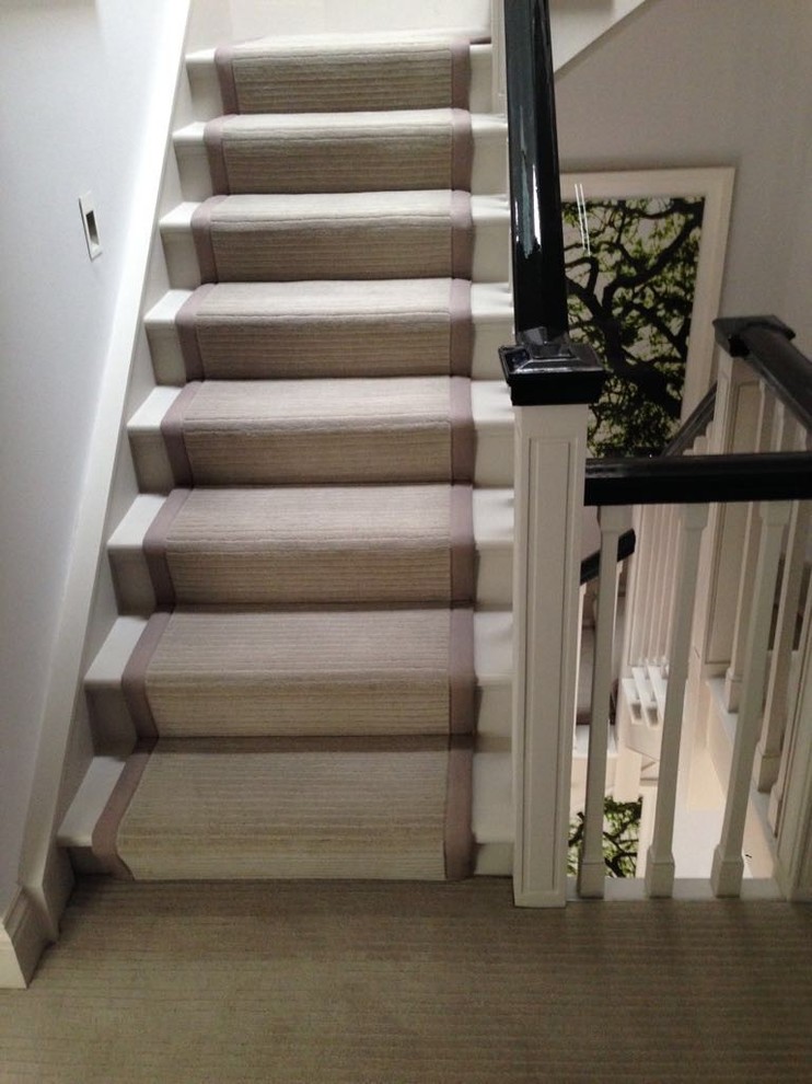 ロンドンにある高級な広いコンテンポラリースタイルのおしゃれな折り返し階段 (カーペット張りの蹴込み板) の写真