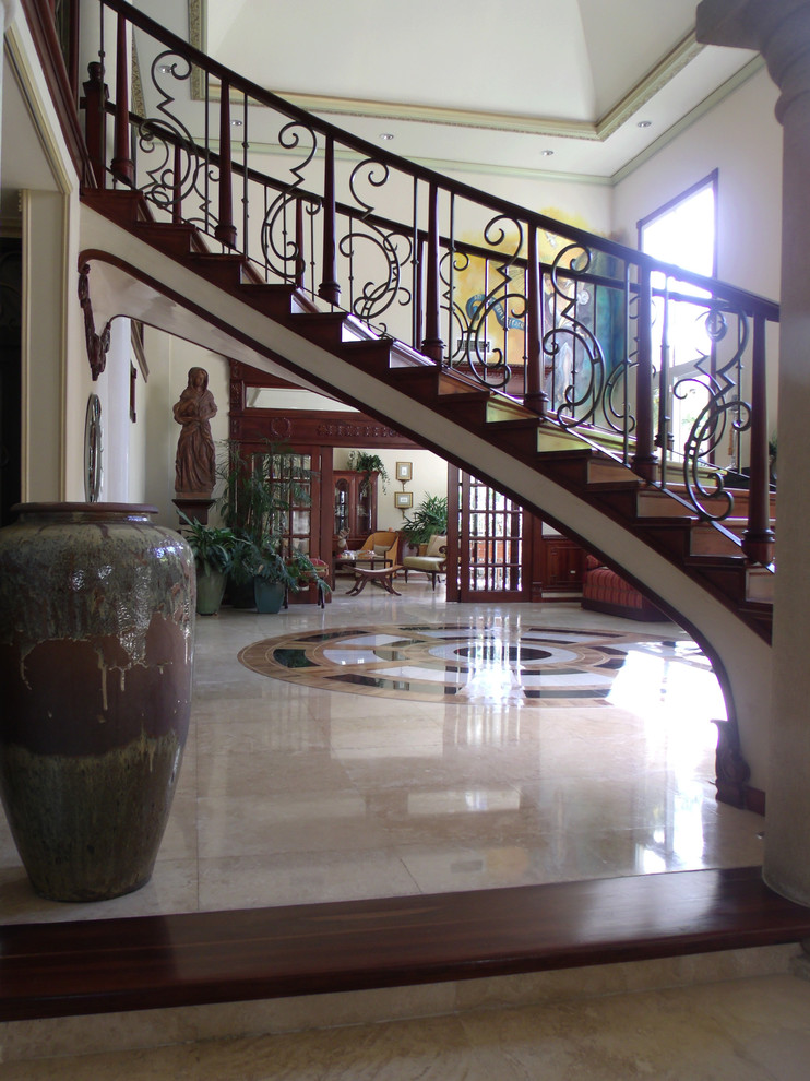 Imagen de escalera curva clásica grande con escalones de madera y contrahuellas de madera