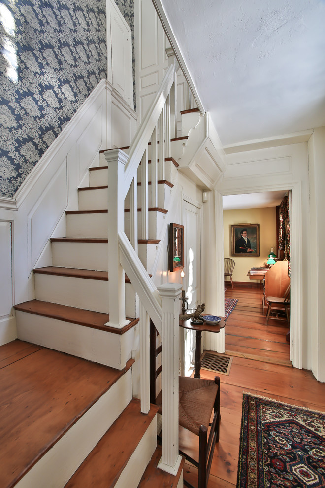 Ejemplo de escalera en L de estilo de casa de campo con escalones de madera y contrahuellas de madera