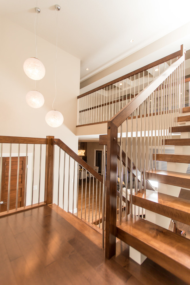 This is an example of a large modern wood u-shaped staircase in Edmonton with open risers.