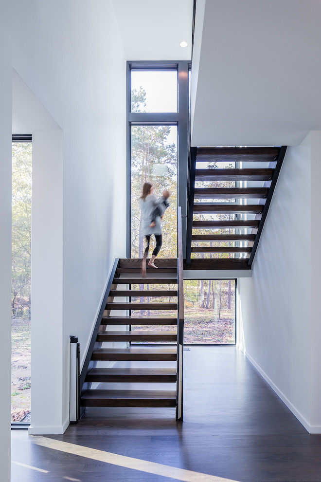 На фото: п-образная лестница в стиле модернизм с деревянными ступенями без подступенок