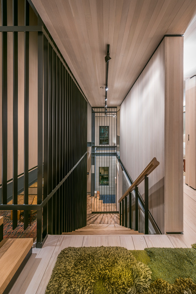 Ejemplo de escalera recta minimalista sin contrahuella con escalones de madera y barandilla de varios materiales