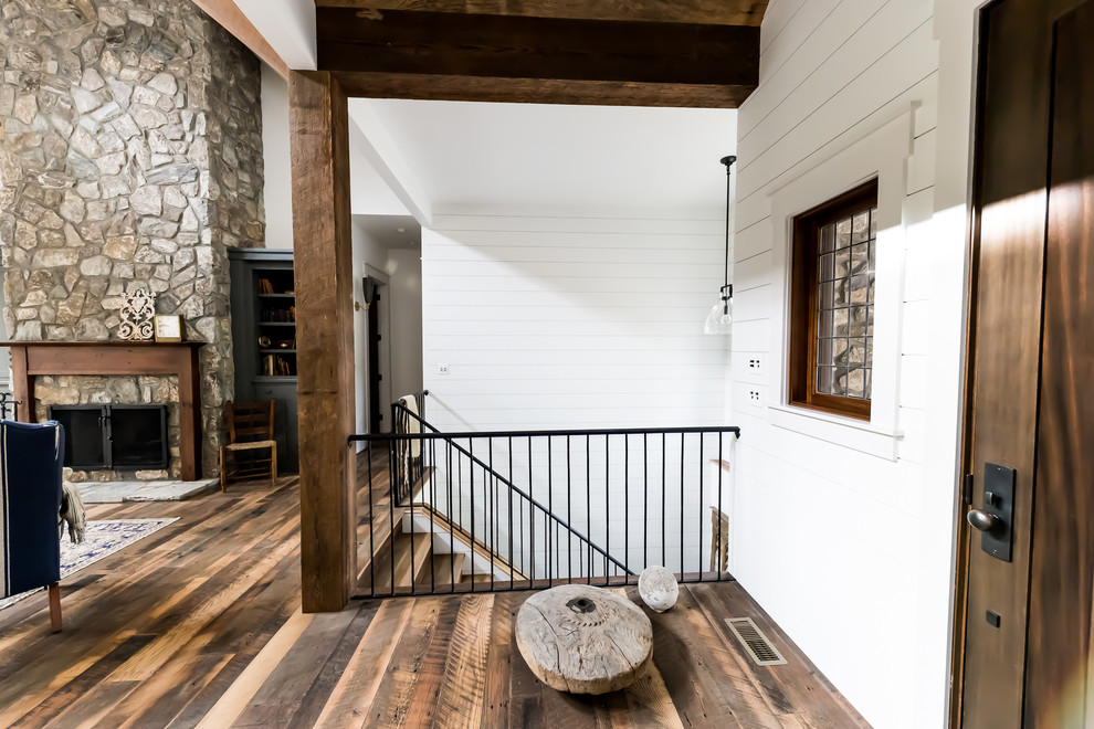 Example of a country wooden u-shaped metal railing staircase design in Other with wooden risers
