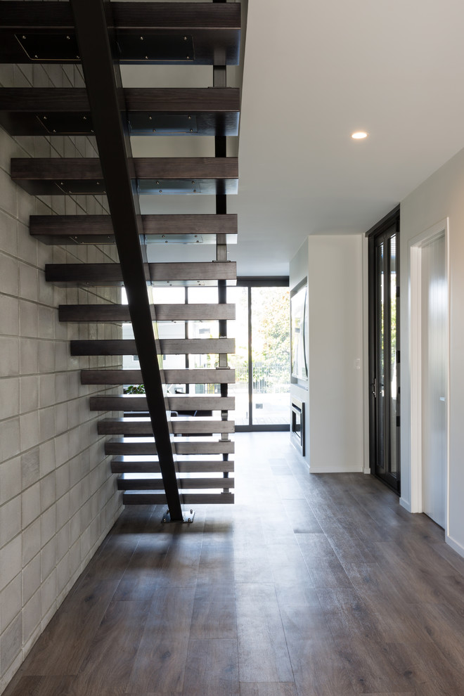Diseño de escalera suspendida industrial de tamaño medio sin contrahuella con escalones de madera y barandilla de metal