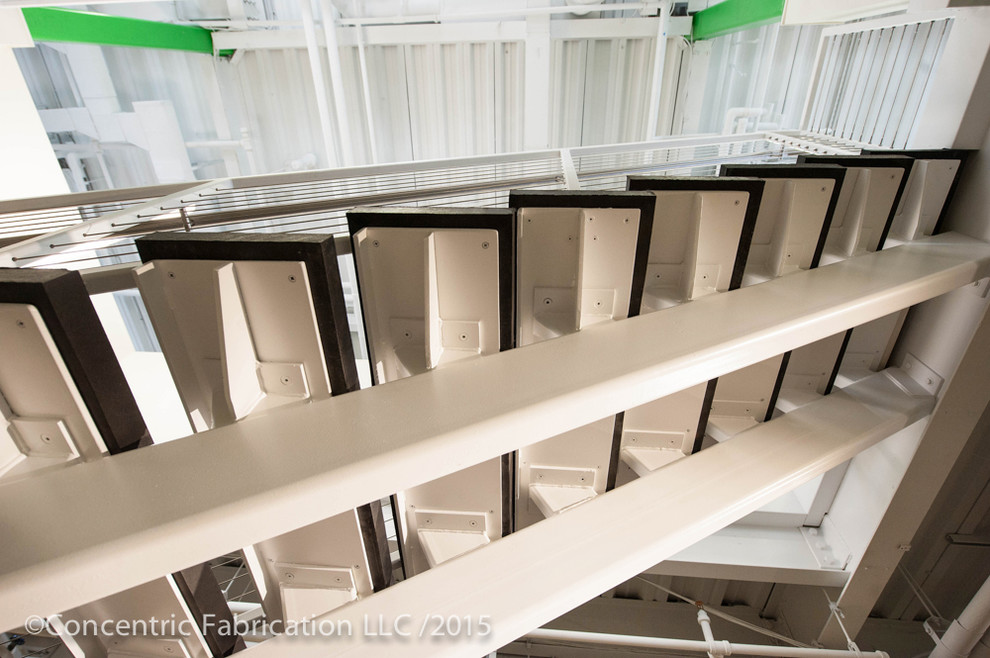 Imagen de escalera en L minimalista de tamaño medio con contrahuellas de metal