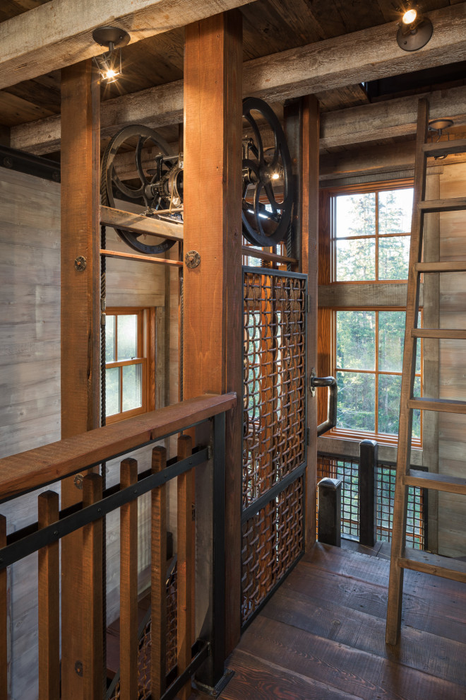 Foto på en mellanstor industriell u-trappa i trä, med öppna sättsteg och räcke i metall