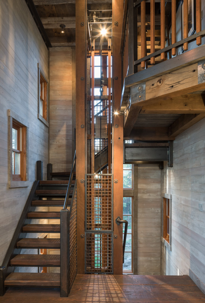 This is an example of a medium sized urban wood u-shaped metal railing staircase in Denver with open risers.