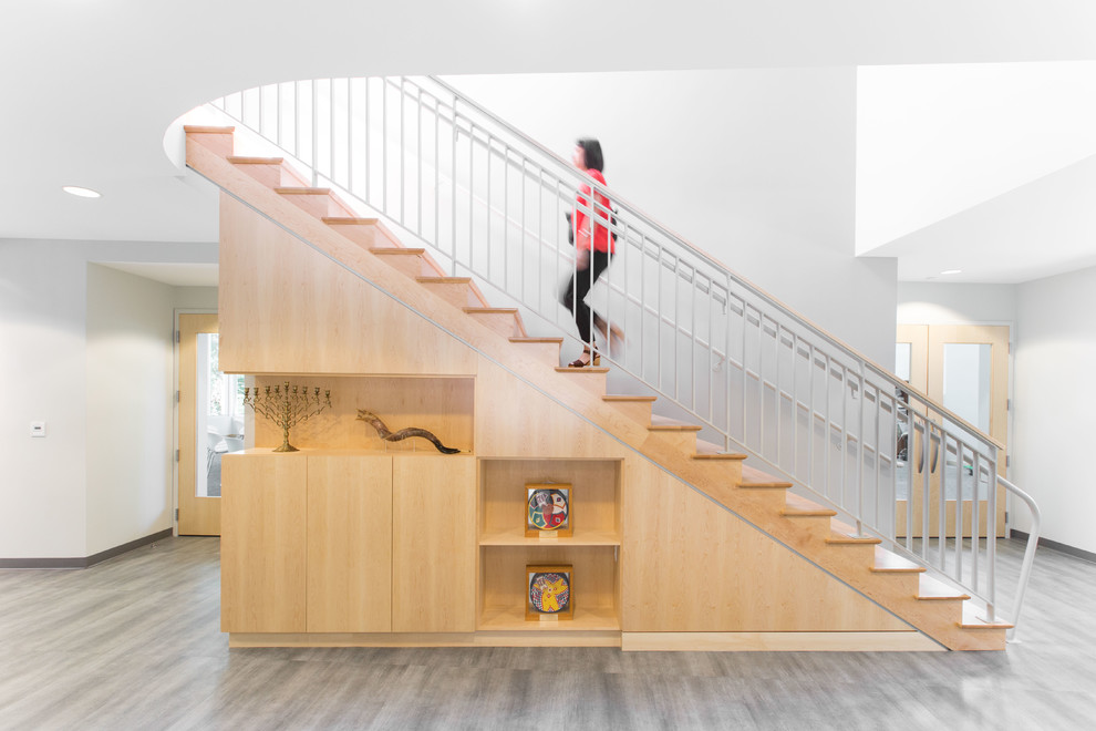 На фото: прямая деревянная лестница среднего размера в современном стиле с деревянными ступенями, металлическими перилами и кладовкой или шкафом под ней