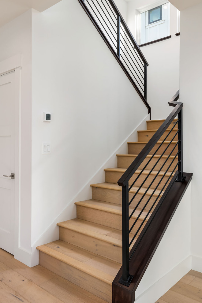 Foto de escalera en U clásica renovada de tamaño medio con escalones de madera, contrahuellas de madera y barandilla de varios materiales