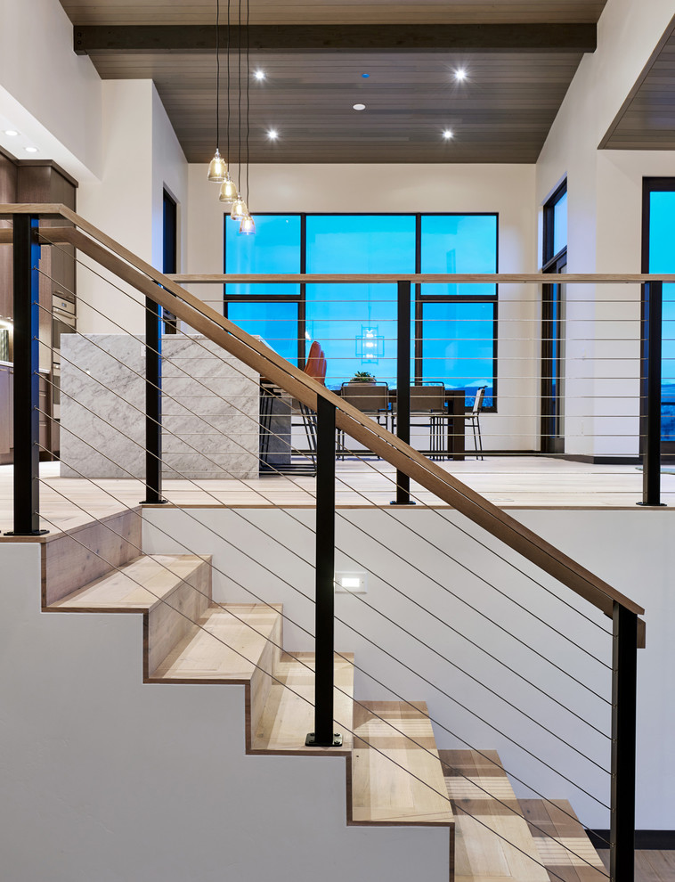 Diseño de escalera en U contemporánea grande con escalones de madera, contrahuellas de madera y barandilla de cable